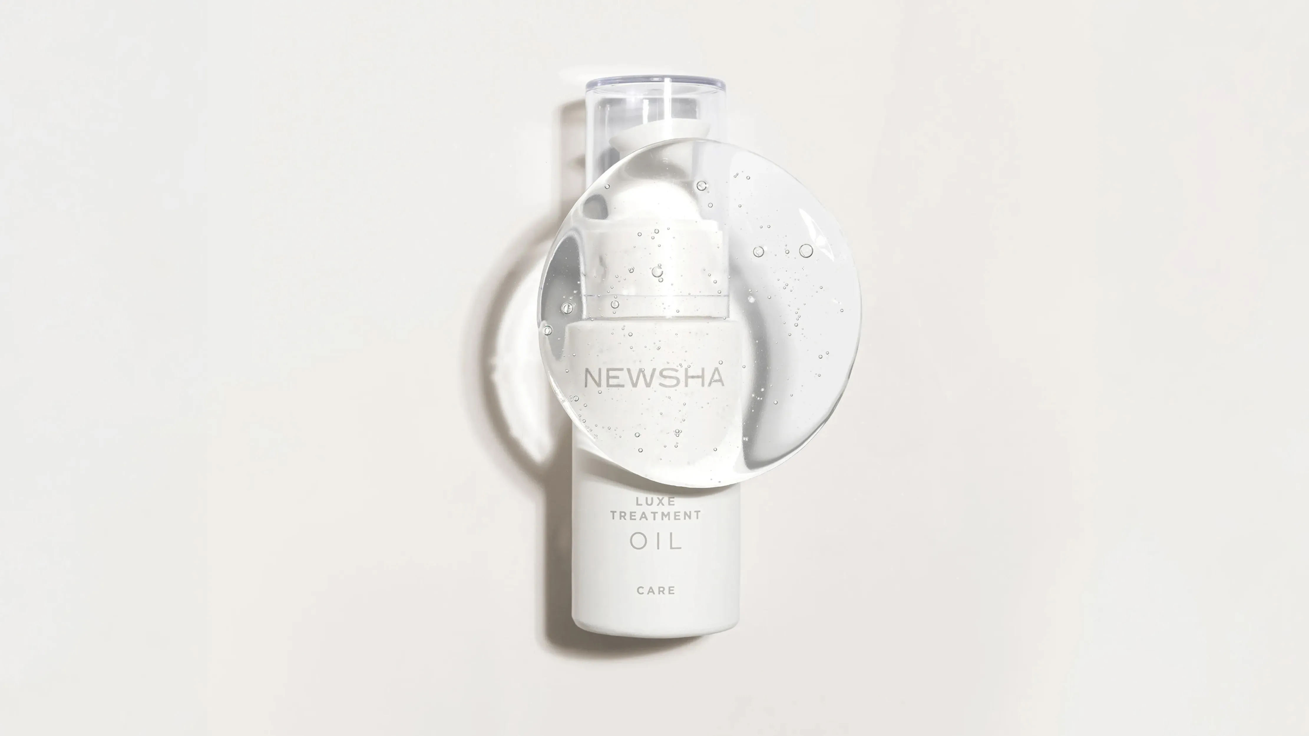 NEWSHA Luxe Treatment Oil vor hellem Hintergrund, inszeniert hinter einer transparenten Gelblase mit feinen Luftbläschen.