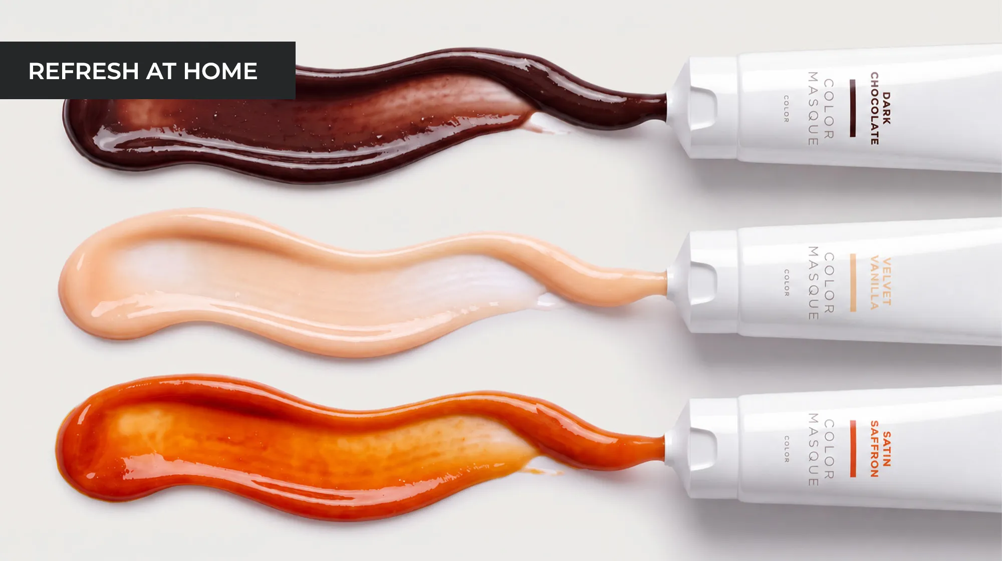 Drei NEWSHA Color Masque Tuben in den Nuancen Dark Chocolate, Velvet Vanilla und Satin Saffron mit passenden Farbtexturen auf weißem Hintergrund.