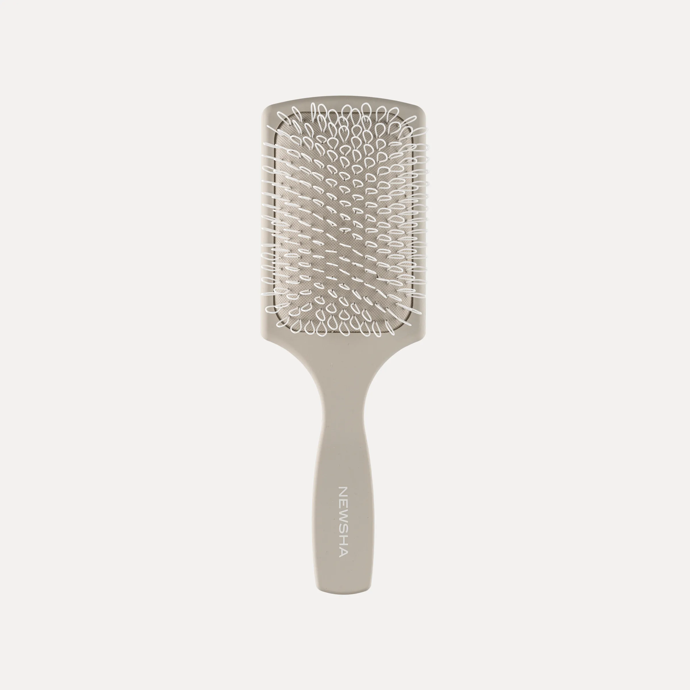 Beige Extensions Care Brush von NEWSHA mit weichen Borsten vor hellem Hintergrund.