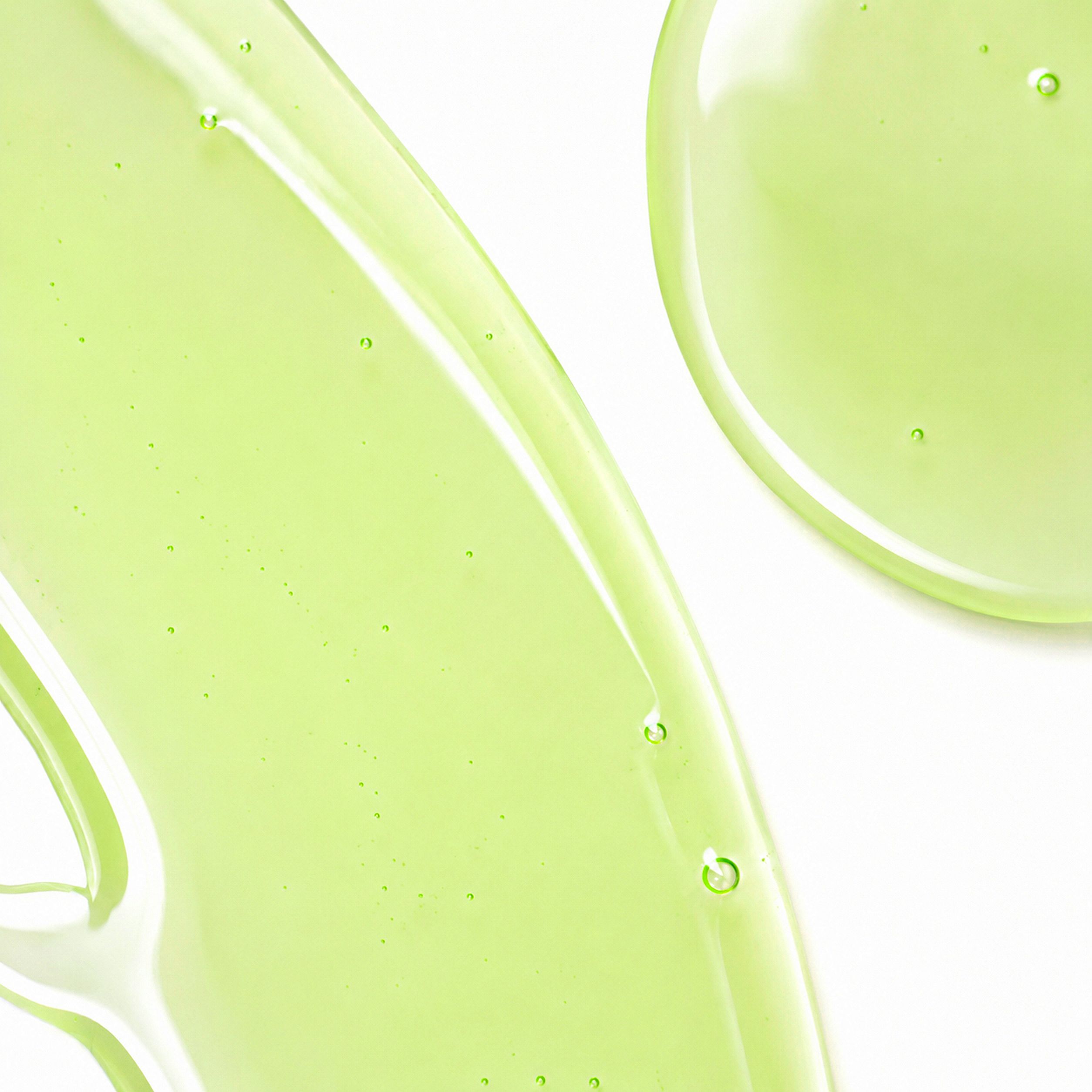 Nahaufnahme einer frischen, hellgrünen Shampoo-Textur mit transparenter Gel-Konsistenz und feinen Bläschen auf weißem Hintergrund.