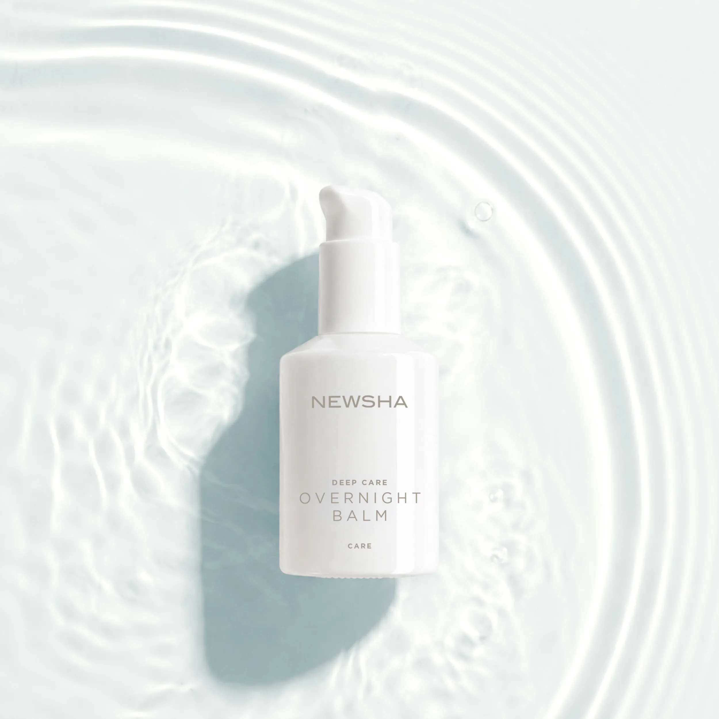 NEWSHA Deep Care Overnight Balm auf einer hellen Wasseroberfl&auml;che mit feinen Lichtreflexen und ruhigen Wasserwellen.