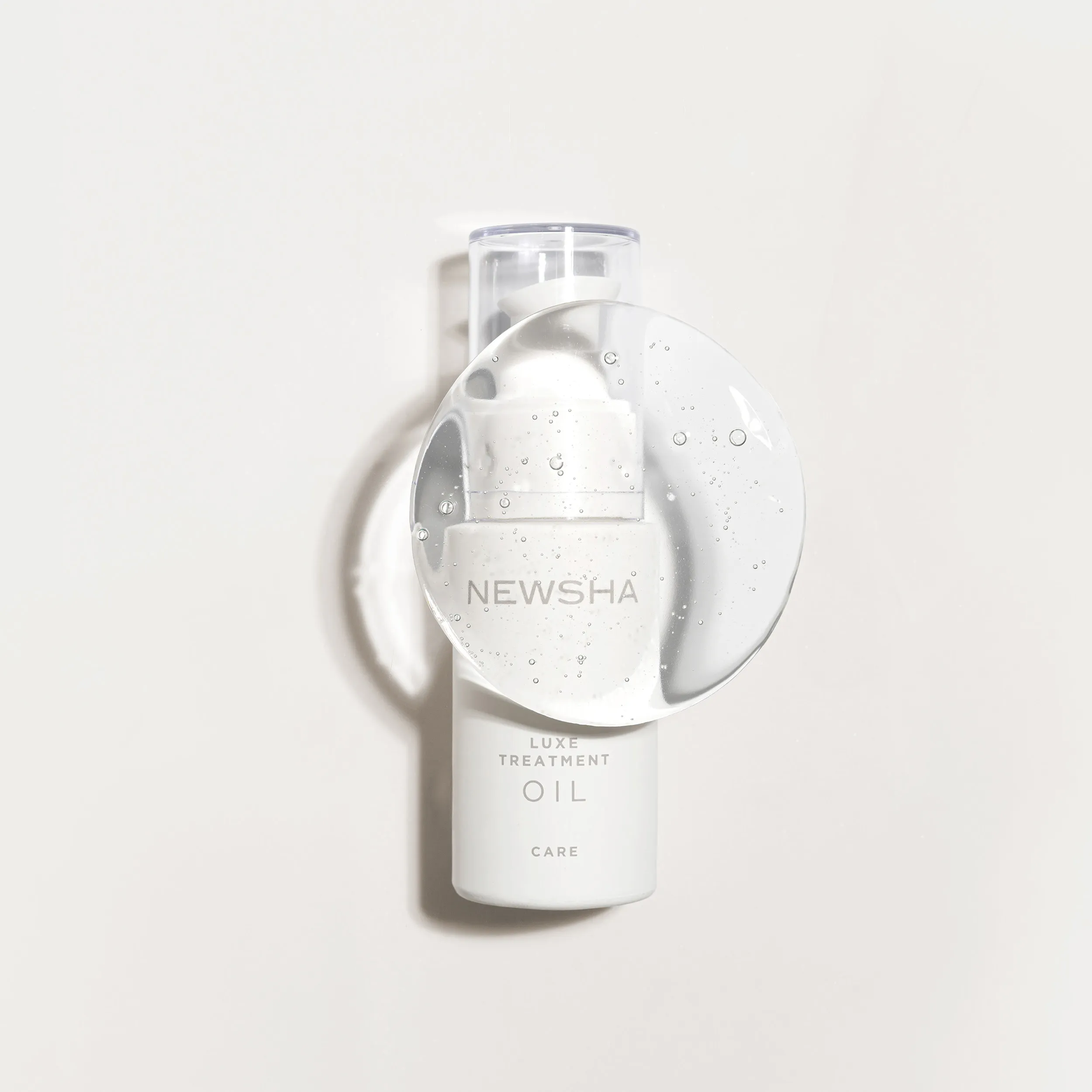 NEWSHA Luxe Treatment Oil als freigestelltes Produktbild mit transparenter Geltextur auf hellem Hintergrund.