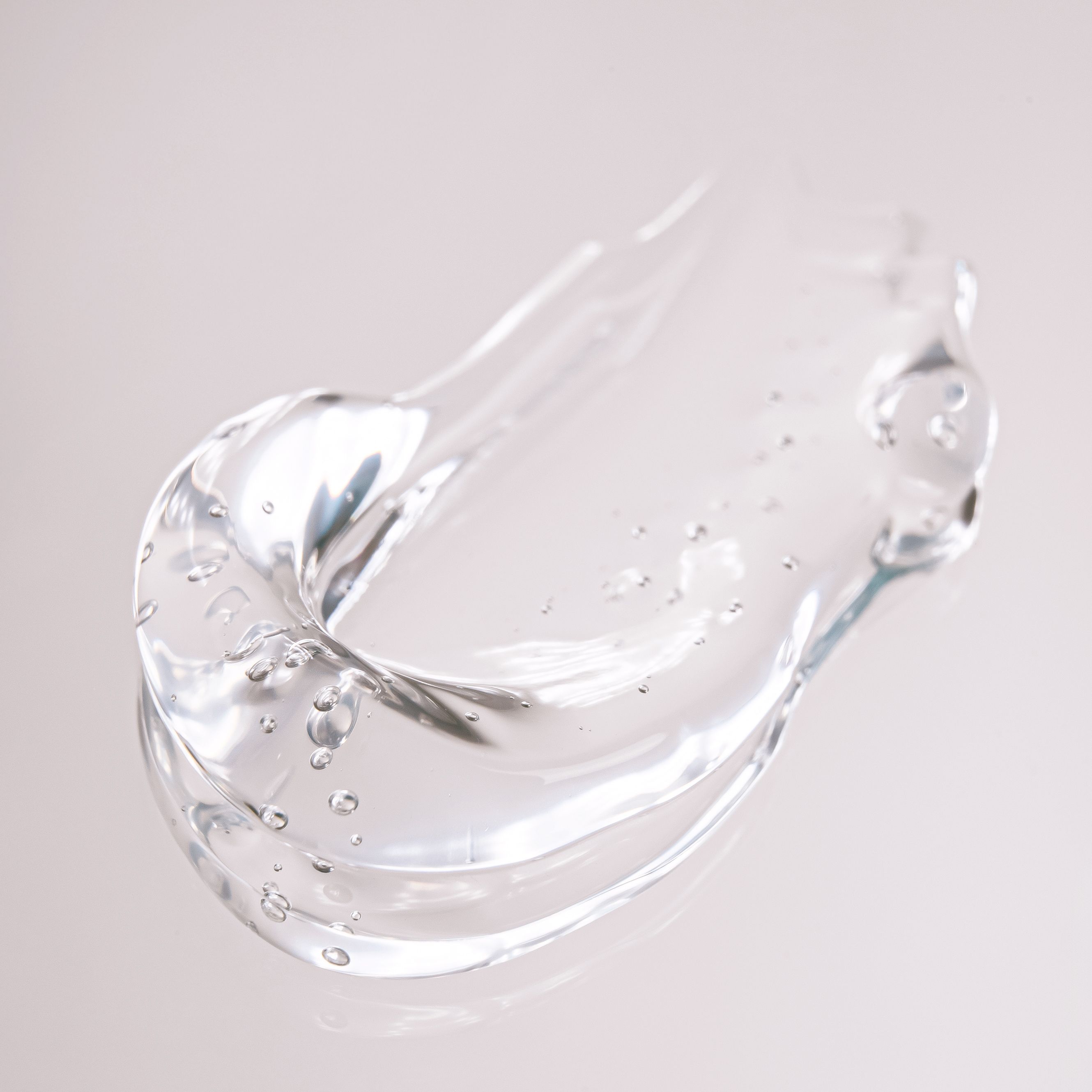 Transparente Geltextur mit feinen Luftbl&auml;schen und gl&auml;nzender Oberfl&auml;che als Nahaufnahme einer leichten Pflegeformulierung.