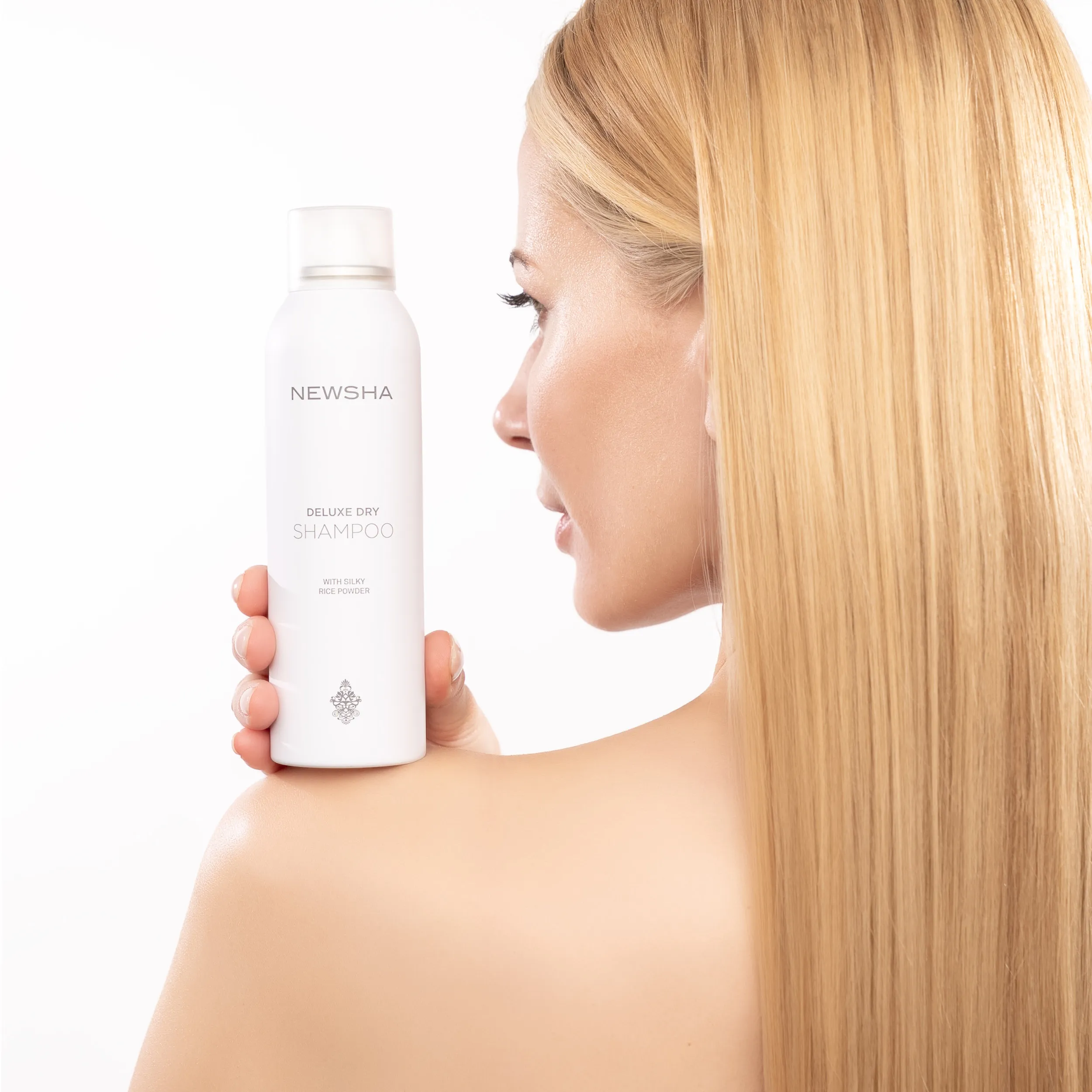 Eine Person schäumt Shampoo in den Händen auf, um das Haar sanft und gründlich zu reinigen.